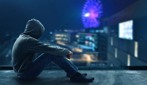 אדם עם קפוצון יושב על מעקה הגג